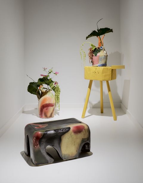 a colorful stool and vessel in a white room