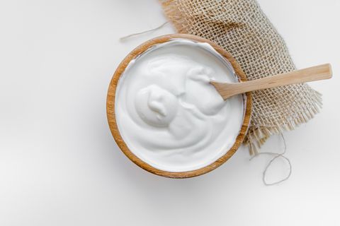 full fat dairy yogurt in a wooden bowl with wooden spoon