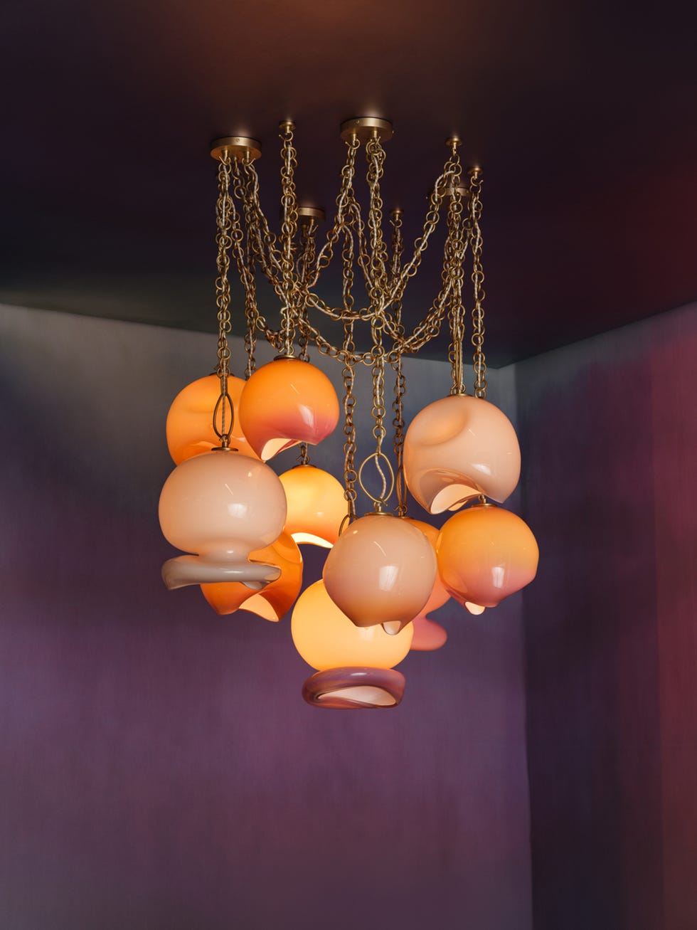 Modern chandelier featuring multiple glass globes in various warm colors.