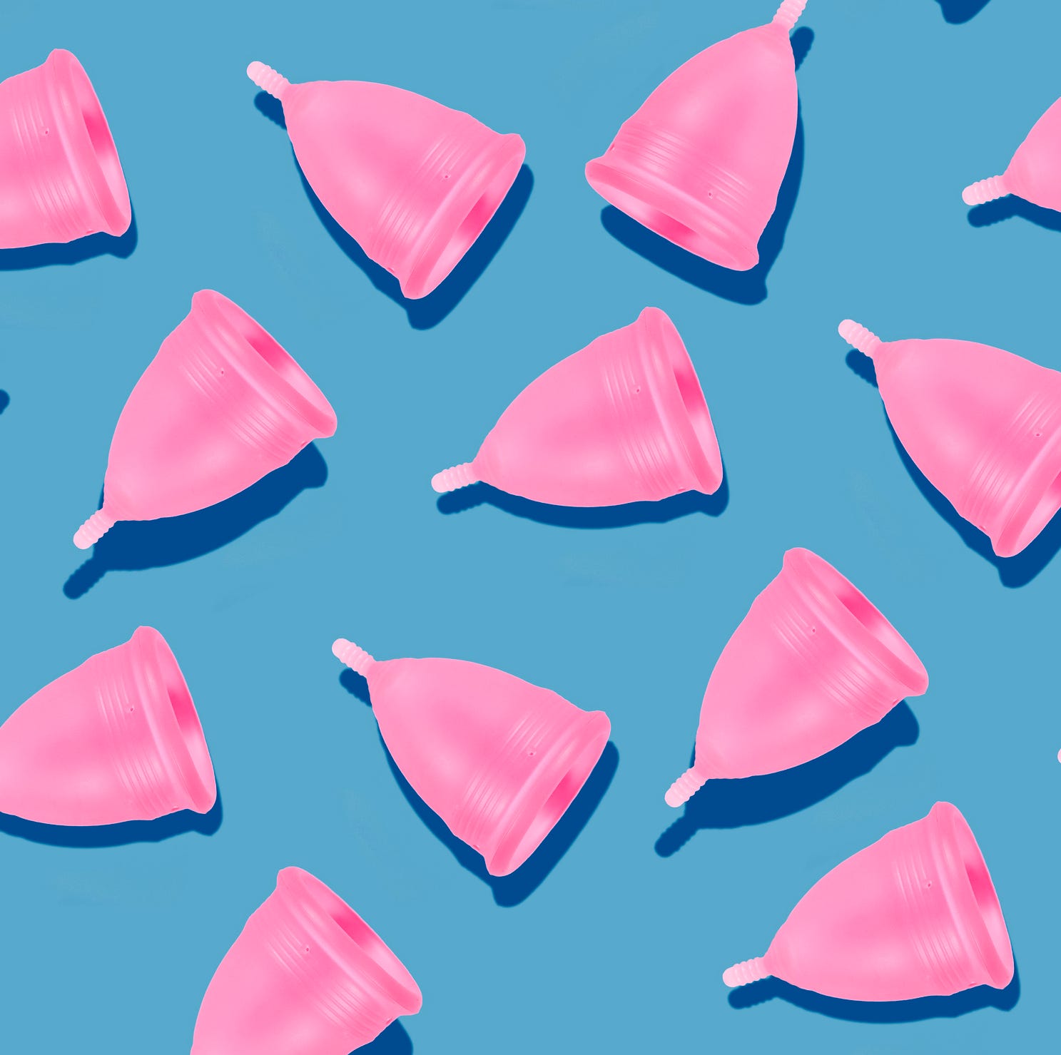 Eco-friendly and reusable pink menstrual cup pattern on blue background