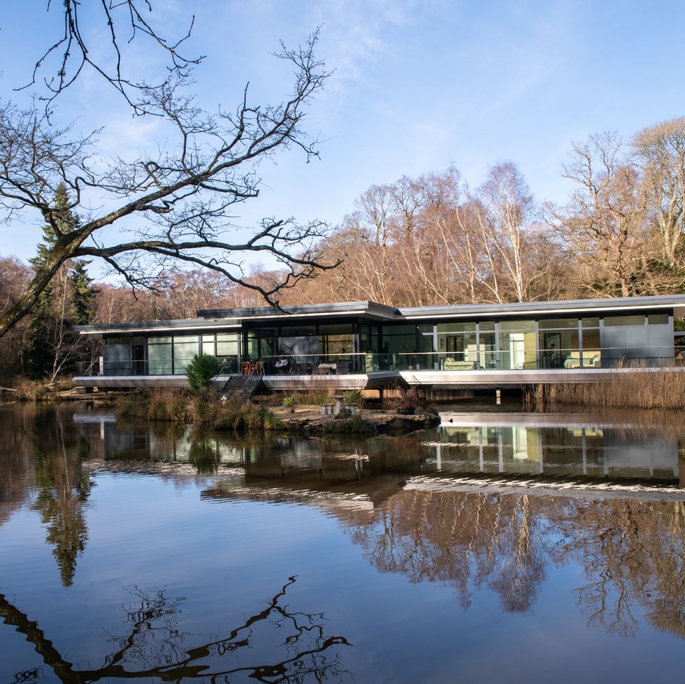 eco home sitting above the water surrounded by trees