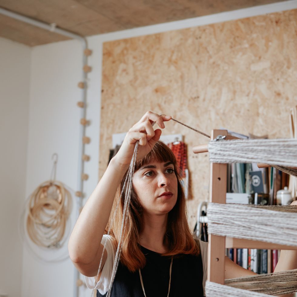 eco hero maria sigma weaving in her studio using textile waste