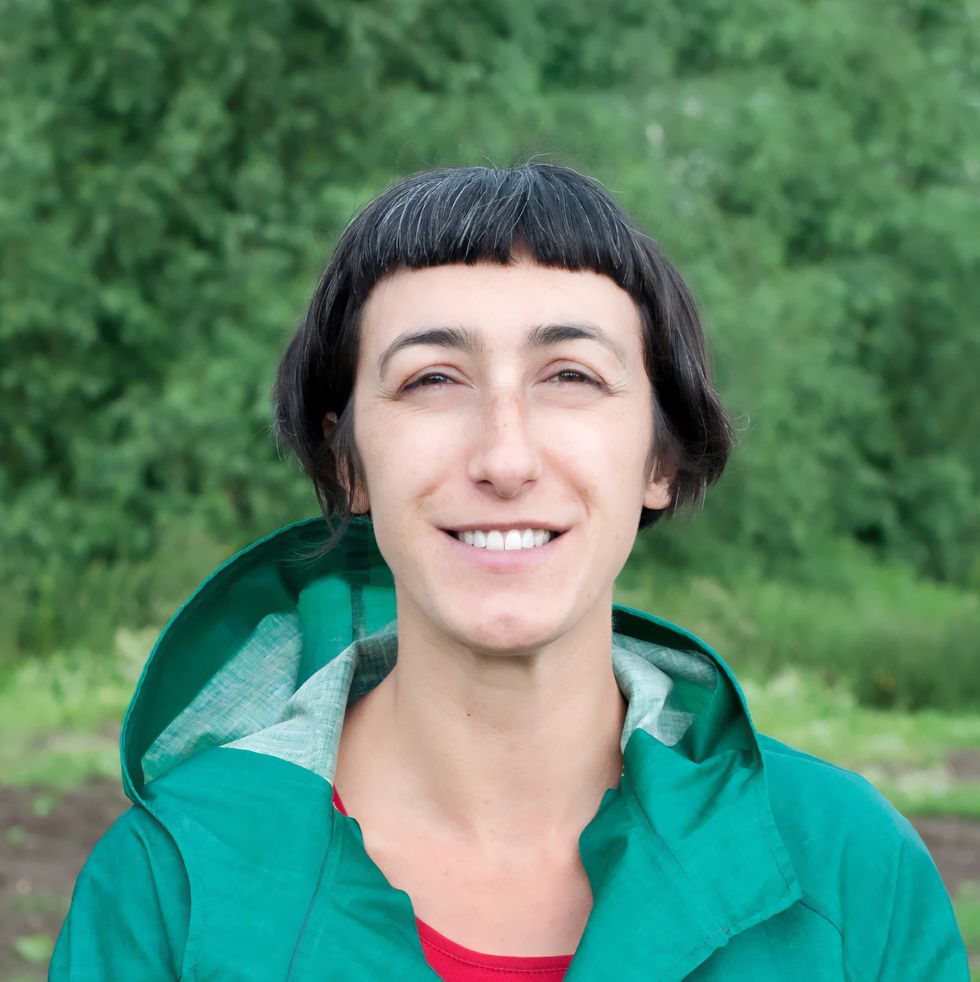 urban worm founder anna de la vega in a green raincoat smiling
