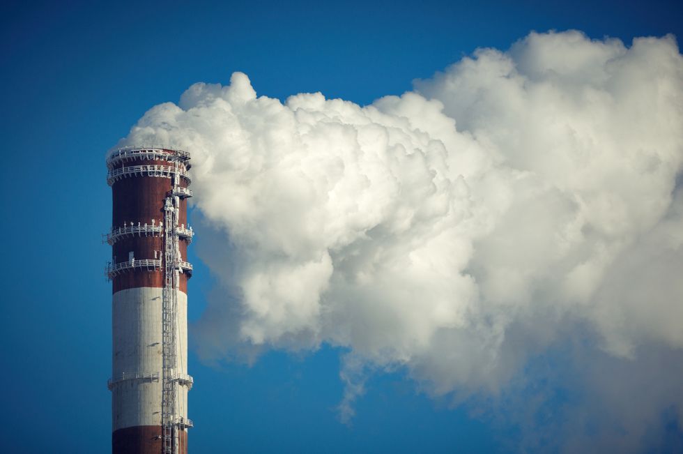 clouds of air pollution rise out of an industrial smoke stack