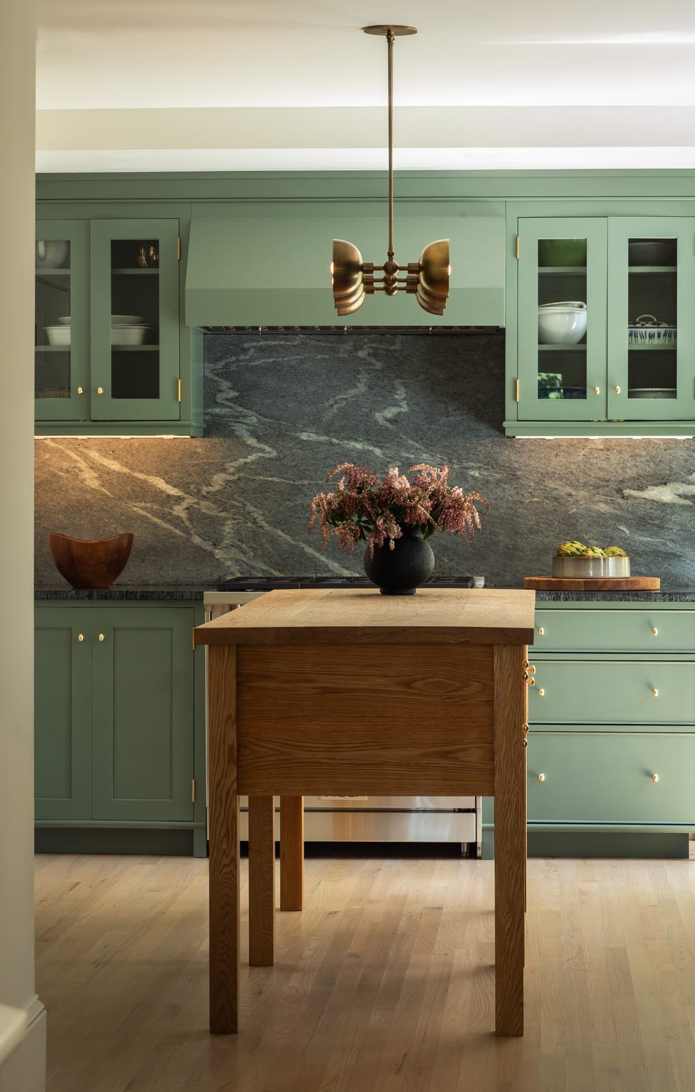 modern kitchen with green cabinetry and wooden island