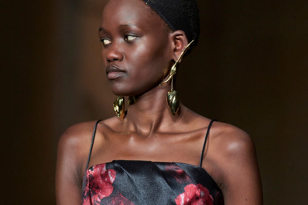 Female fashion model showcasing a floralpatterned dress and bold earrings