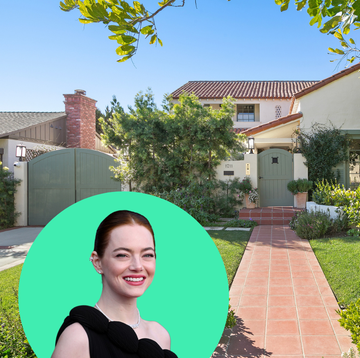 a person smiling with a green helmet in front of a house