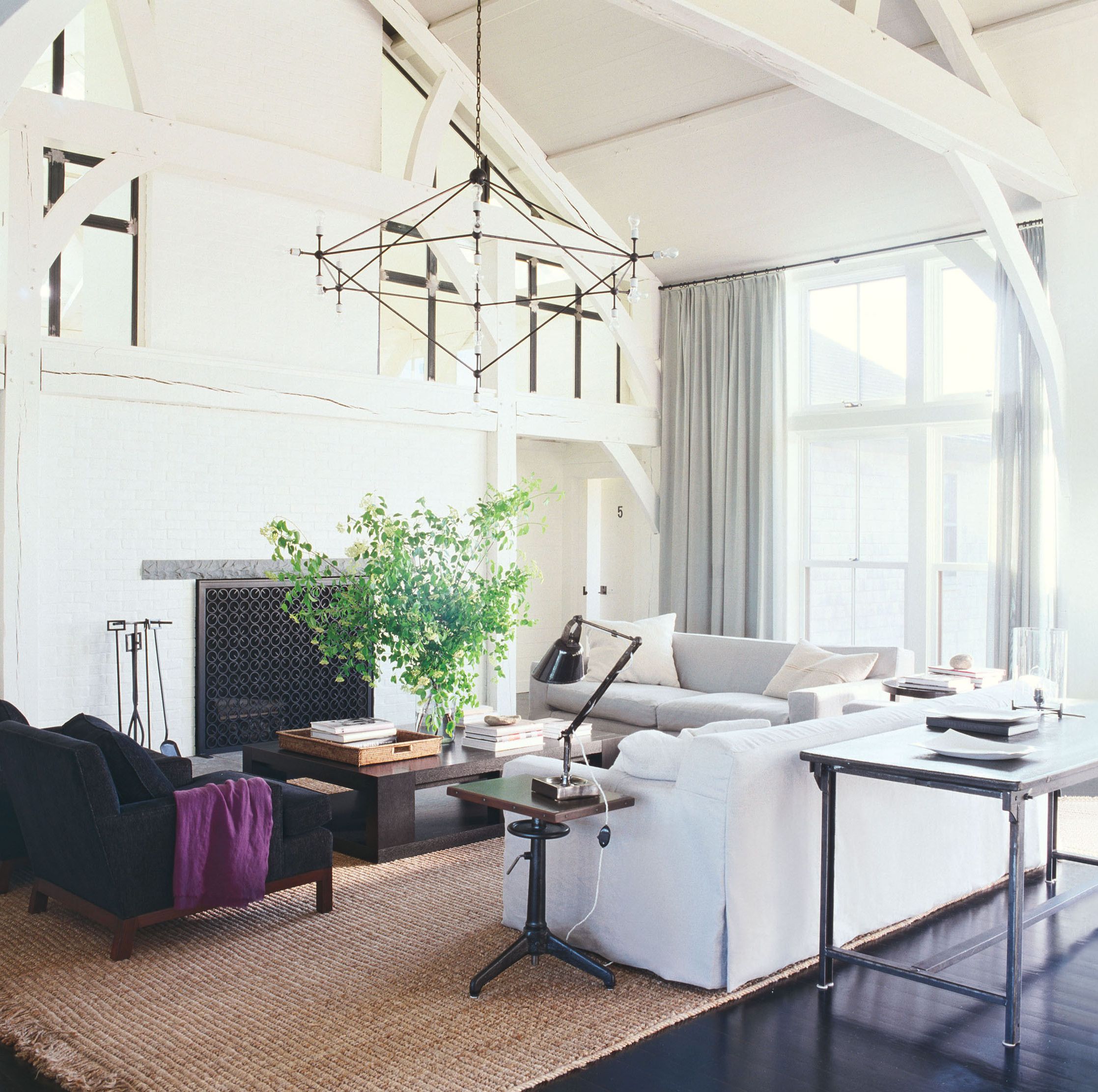 white living room with high beamed ceilings and dark wood floors and a fireplace