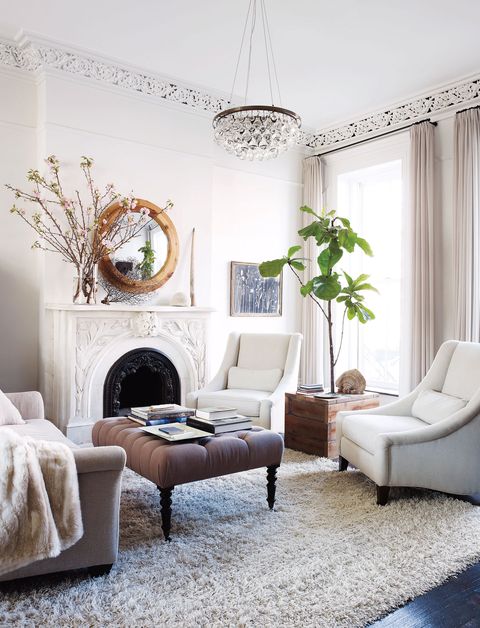 the living room features linen upholstered armchairs by mitchell gold and bob williams a rug by shaw floors and an ochre light fixture deary built the side table and mirror from reclaimed wood and the tufted ottoman and hugo guinness drawing are from john derian dry goods
