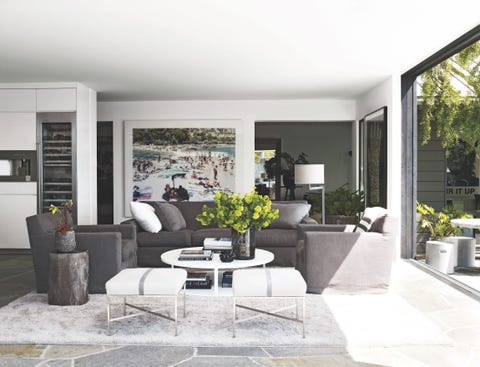 an open airy white sitting area with gray sofa and chairs