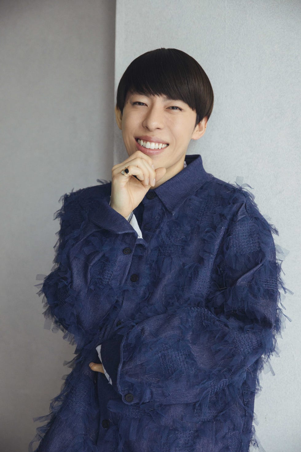 a person smiling and wearing a blue jacket