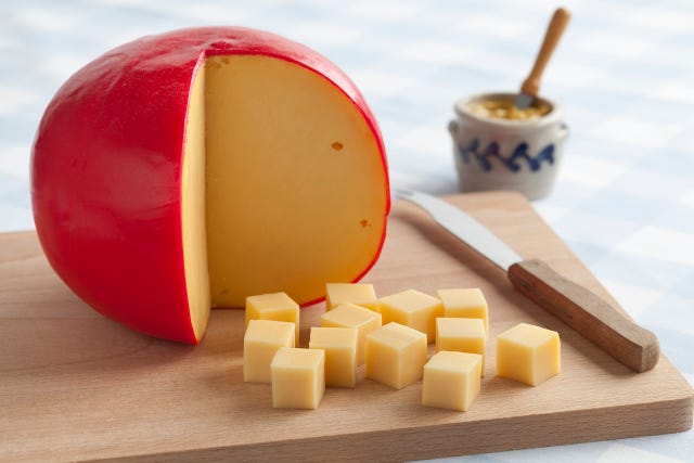 edam cheese and cubes on a cutting board