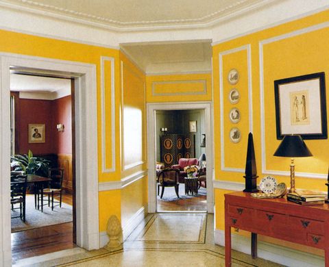 sunny yellow painted entryway with white trim leading into several rooms