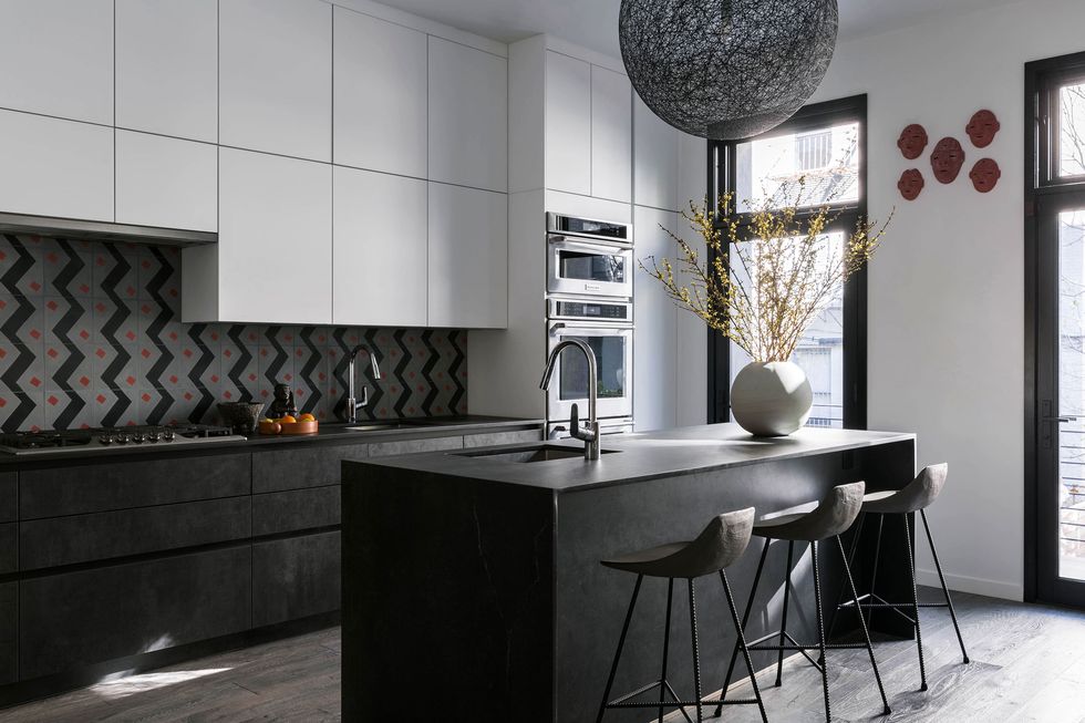 a white and black kitchen with an island and bar stools