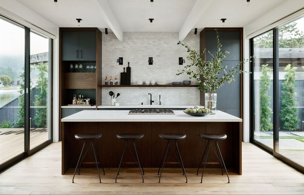 a kitchen with glass doors on either side with an island and black cabinets