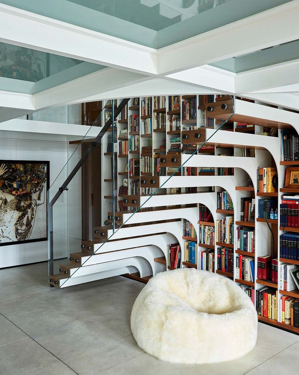library with floating staircase and white pouf at the bottom