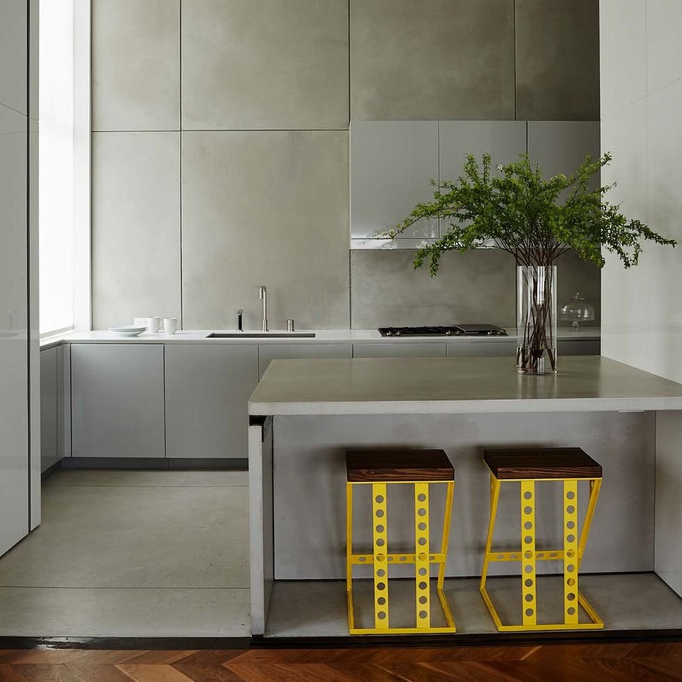 minimalist kitchen with concrete floors and yellow counterstools