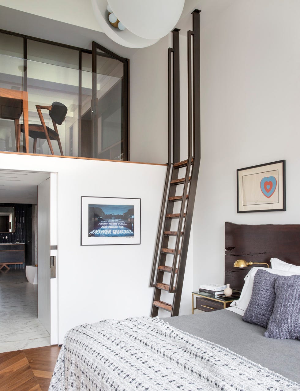 first floor bedroom with a ladder that goes to up to a lofted space