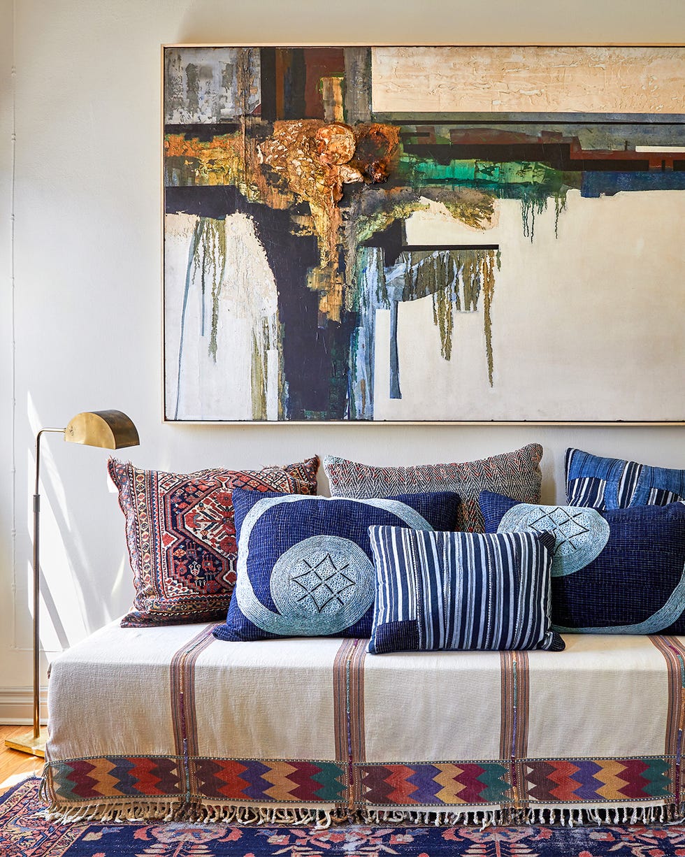 Room, Furniture, Interior design, Living room, Wall, Table, House, Textile, Home, Bedroom, daybed with lots of pillows on it and a vintage blueish rug underfoot