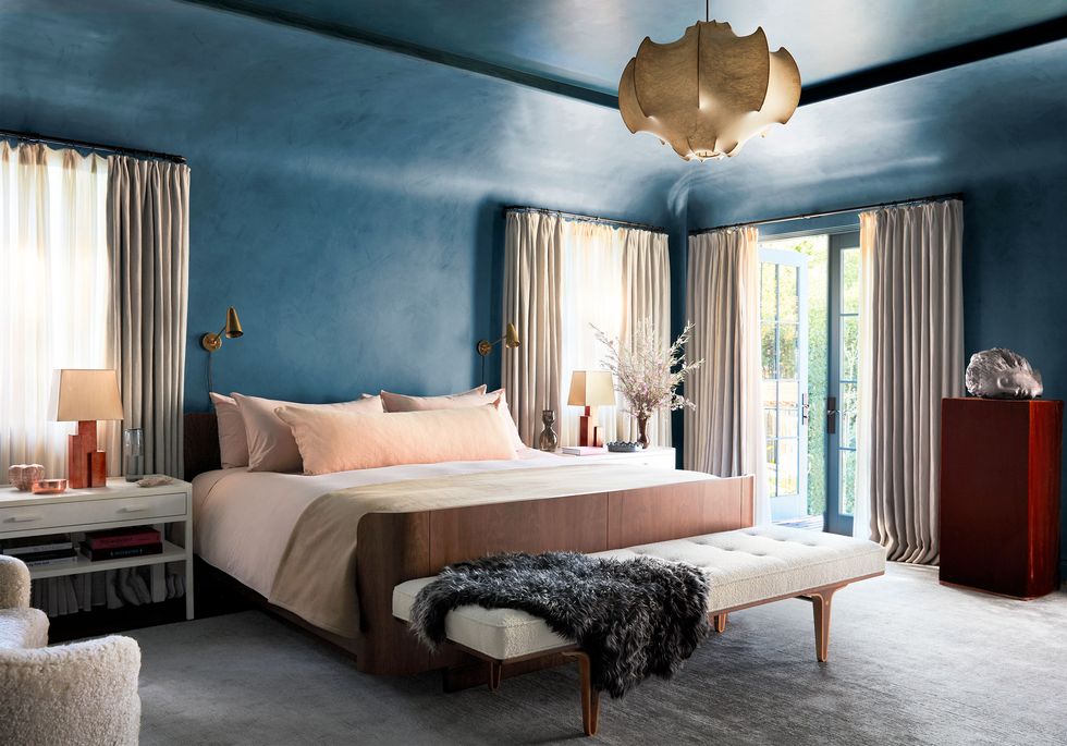 bedroom with blue walls and tall draped windows