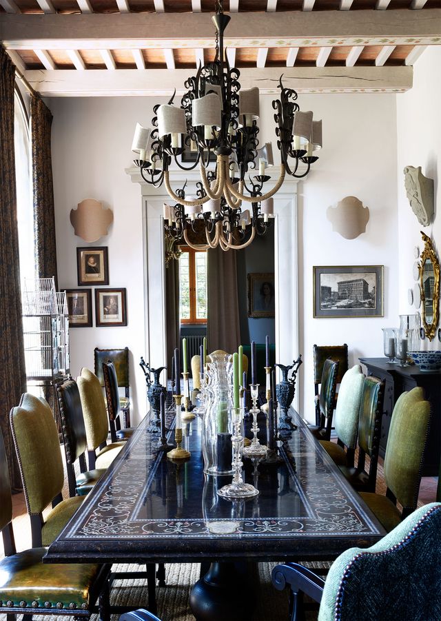black dining table with leather chairs  and chandelier center