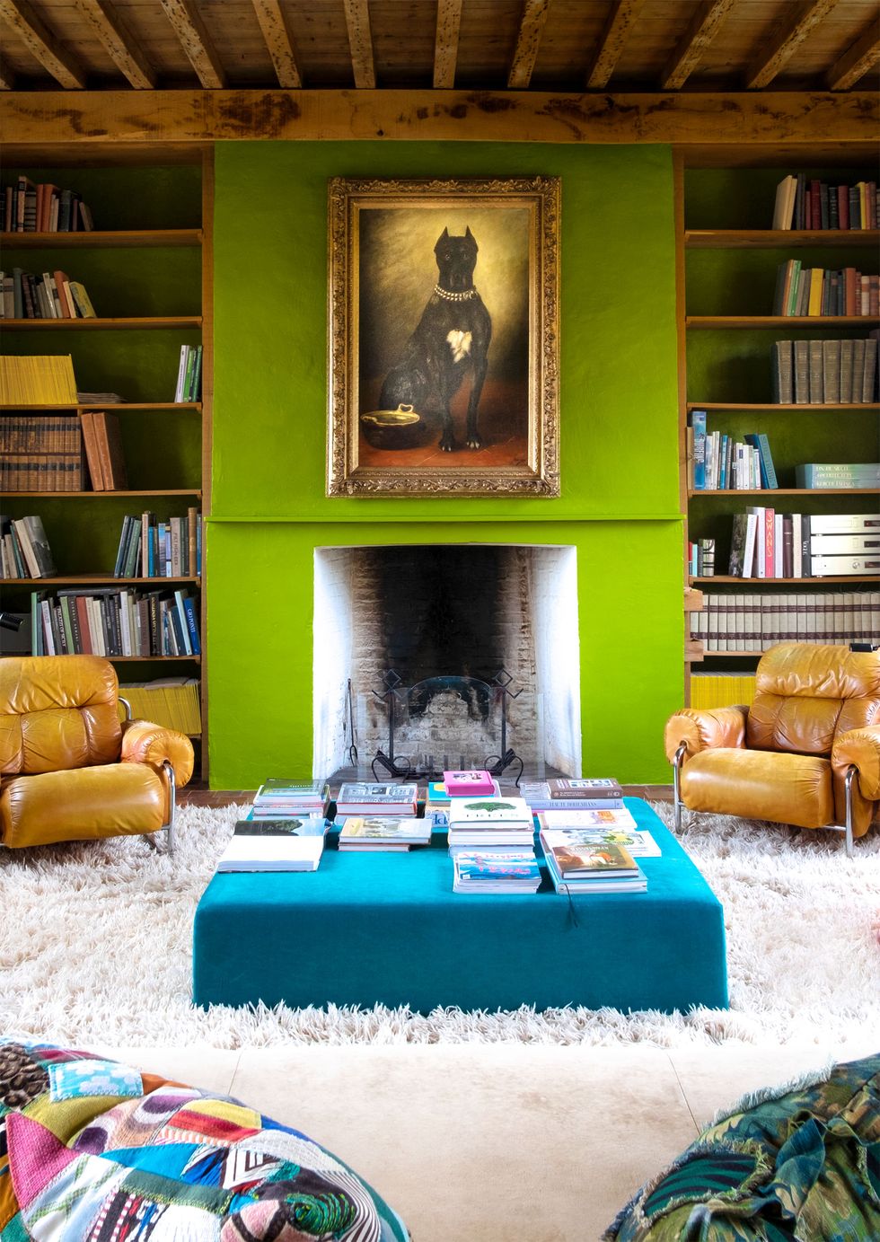 bright green mantel at center with yellow chairs to each side and a low square blue table in front and a very shaggy white rug underneath the furniture