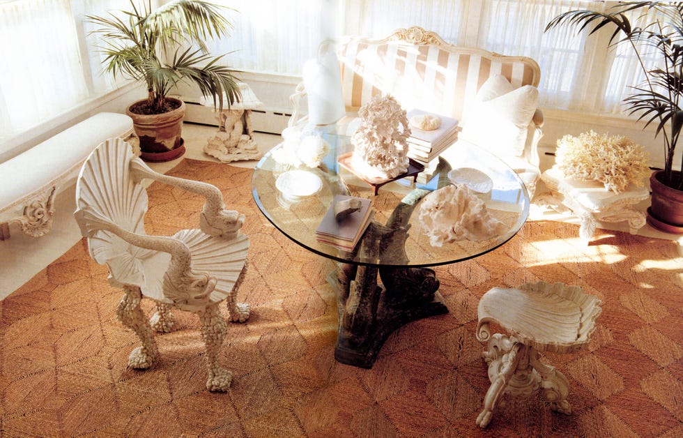 a table with chairs and a glass coffee table with objects on it