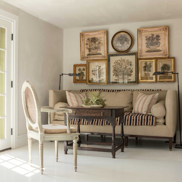 cozy beige nook with a sofa table and chair and gallery wall by bunny williams
