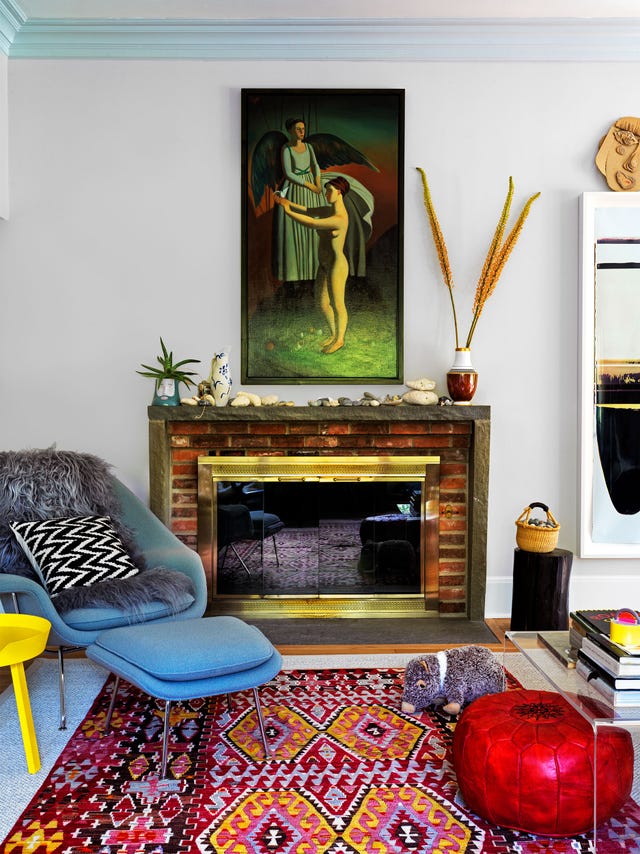 room with patterned carpet, chaise, and fireplace