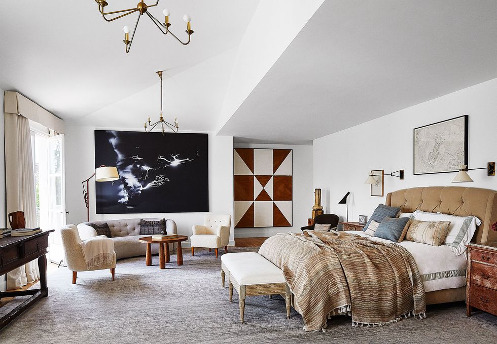 bedroom with several pieces of artwork on the white walls and high ceilings