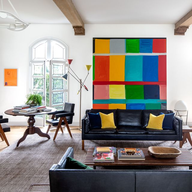 living room with black leather sofas and a colorful painting