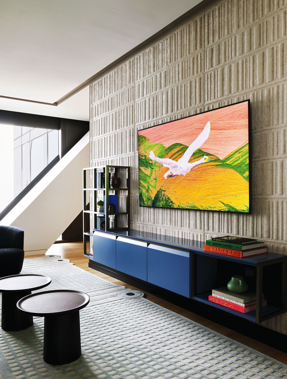 floating media console with blue doors, painting above on a textured wall