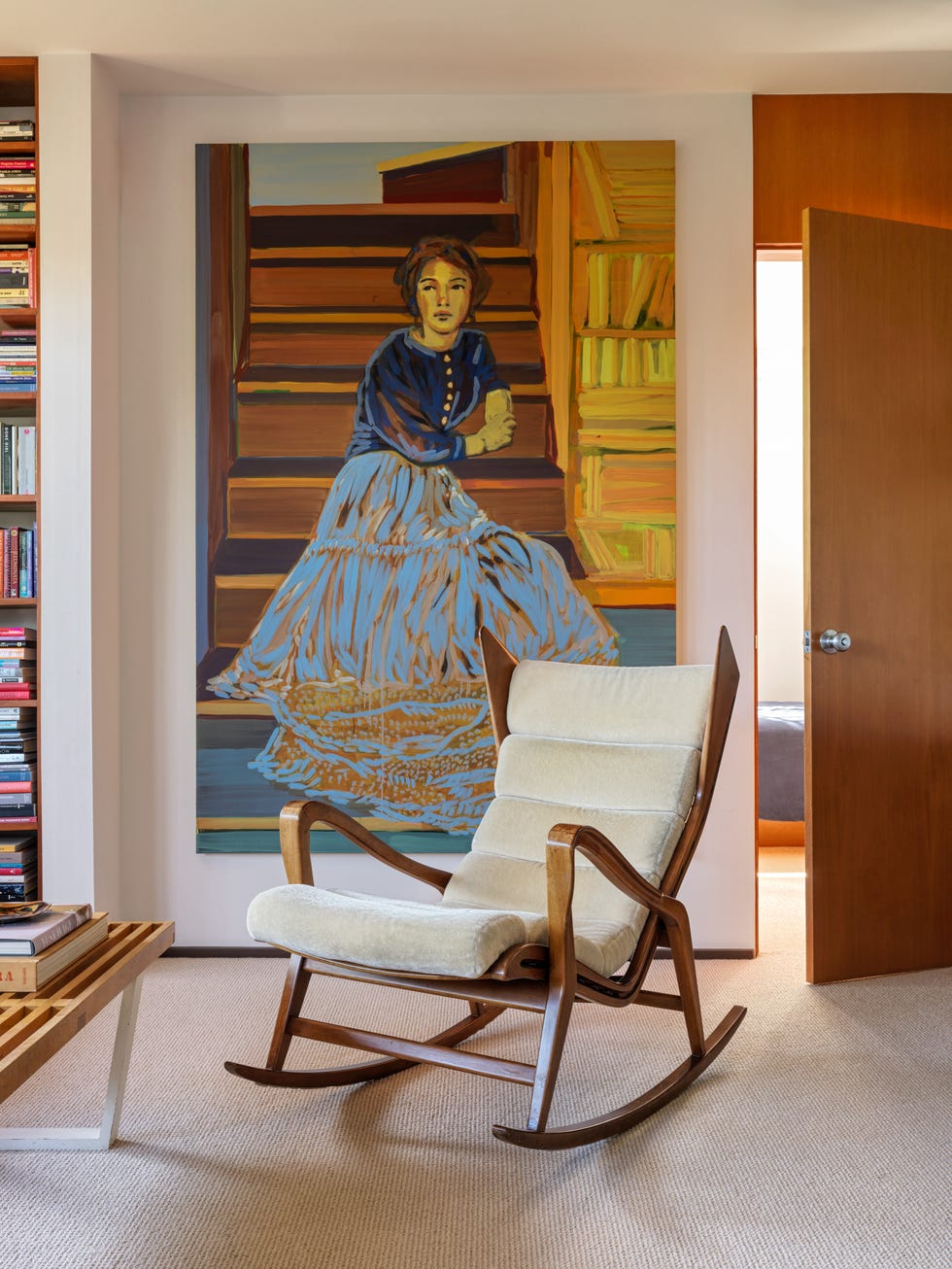 interior scene featuring a cozy chair and a decorative mural