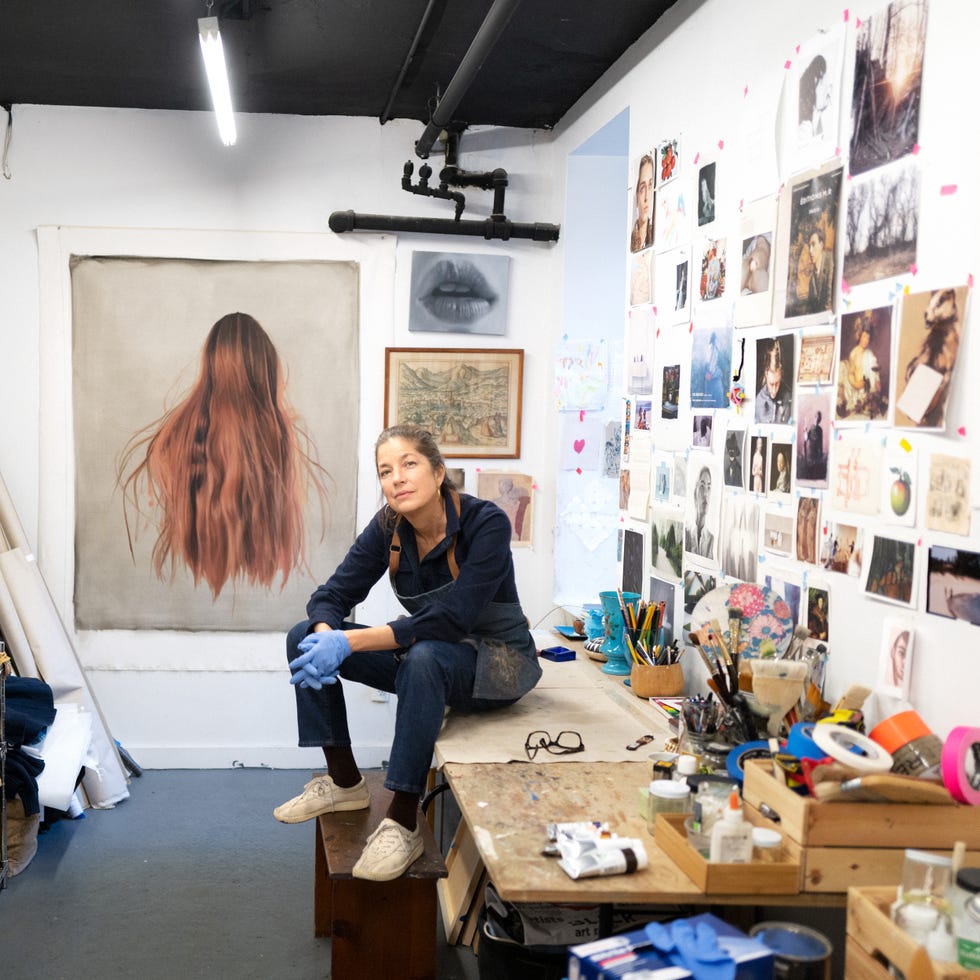 art studio with various artworks and an artist preparing for work