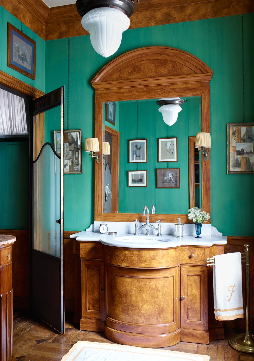 wooden vanity in green bathroom