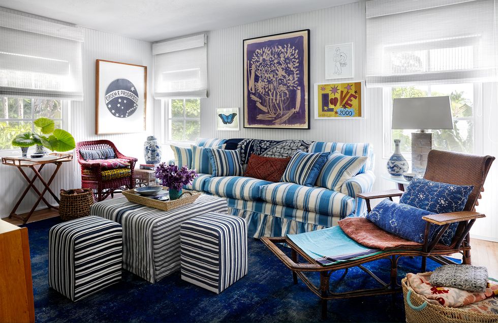 living area with striped blue and white sofa with several striped large poofs