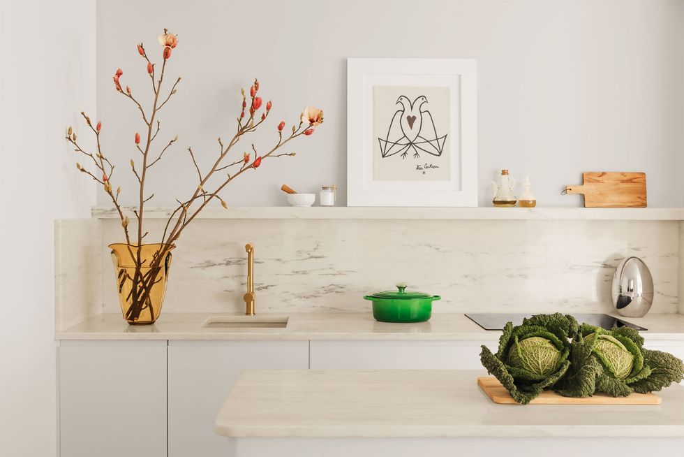 a white counter with a vase and a plant on it