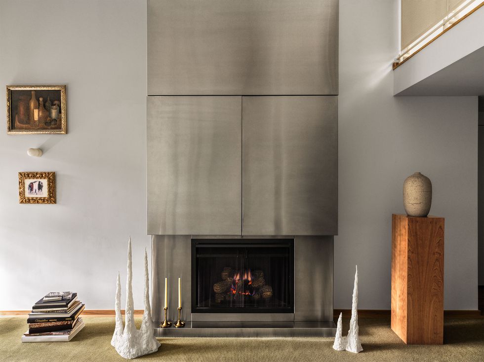 Panoramic view of the fireplace covered in stainless steel from mantel to ceiling