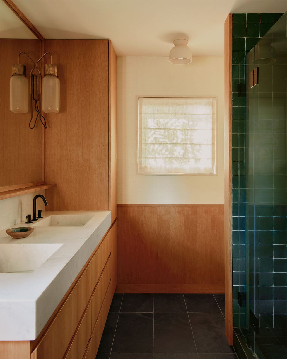 bathroom with modern honey colored wood and white marble double sinks and a green tile on floor and in shower stall