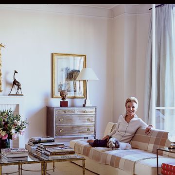 lee radziwill in the living room of her paris apartment with her cockapoo zinnia the sofa is one of christian liaigres early designs and the steel commode gilded bronze cocktail tables and giraffe sculpture are vintage