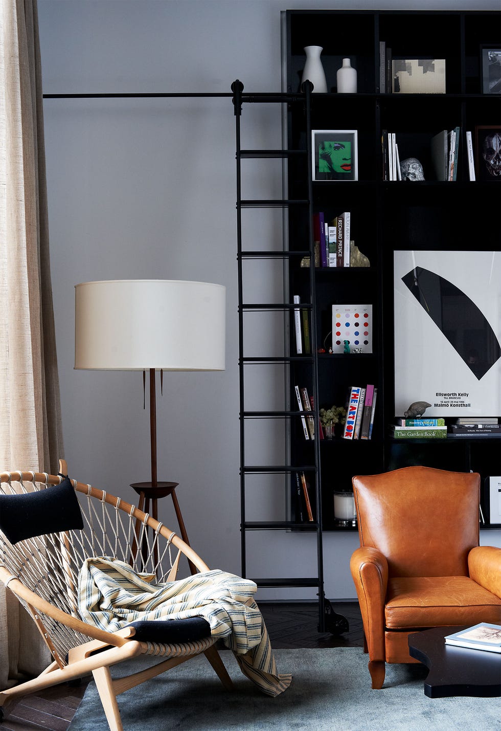 a hans wegner hoop chair from wyeth a lamp by bddw and a rug by the rug company in the living area