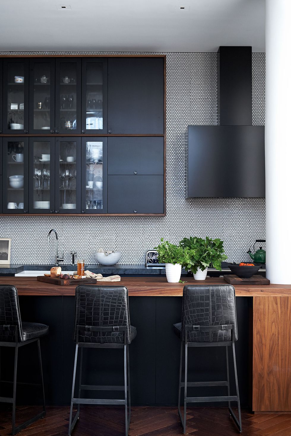 the kitchen cabinets and hood are custom designs the barstools by lawson fenning are covered in a leather by edelman and the penny tiles are by ann sacks
