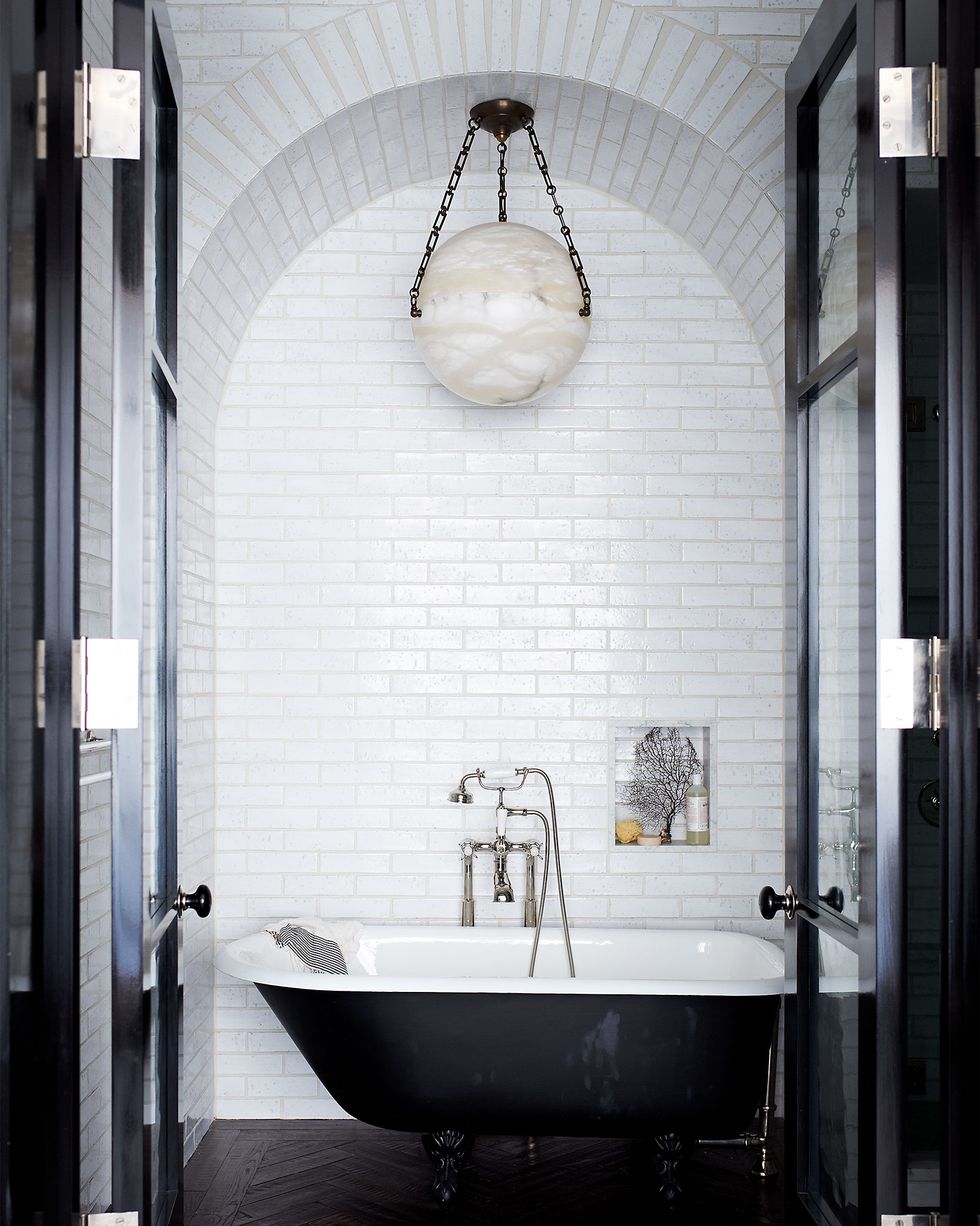 the tub fittings and tiles in the master bath are all by waterworks and the vintage light fixture is from jf chen