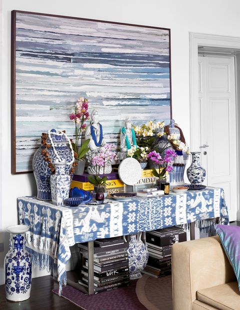 console draped with blue ikat and blue and white porcelain vases and books