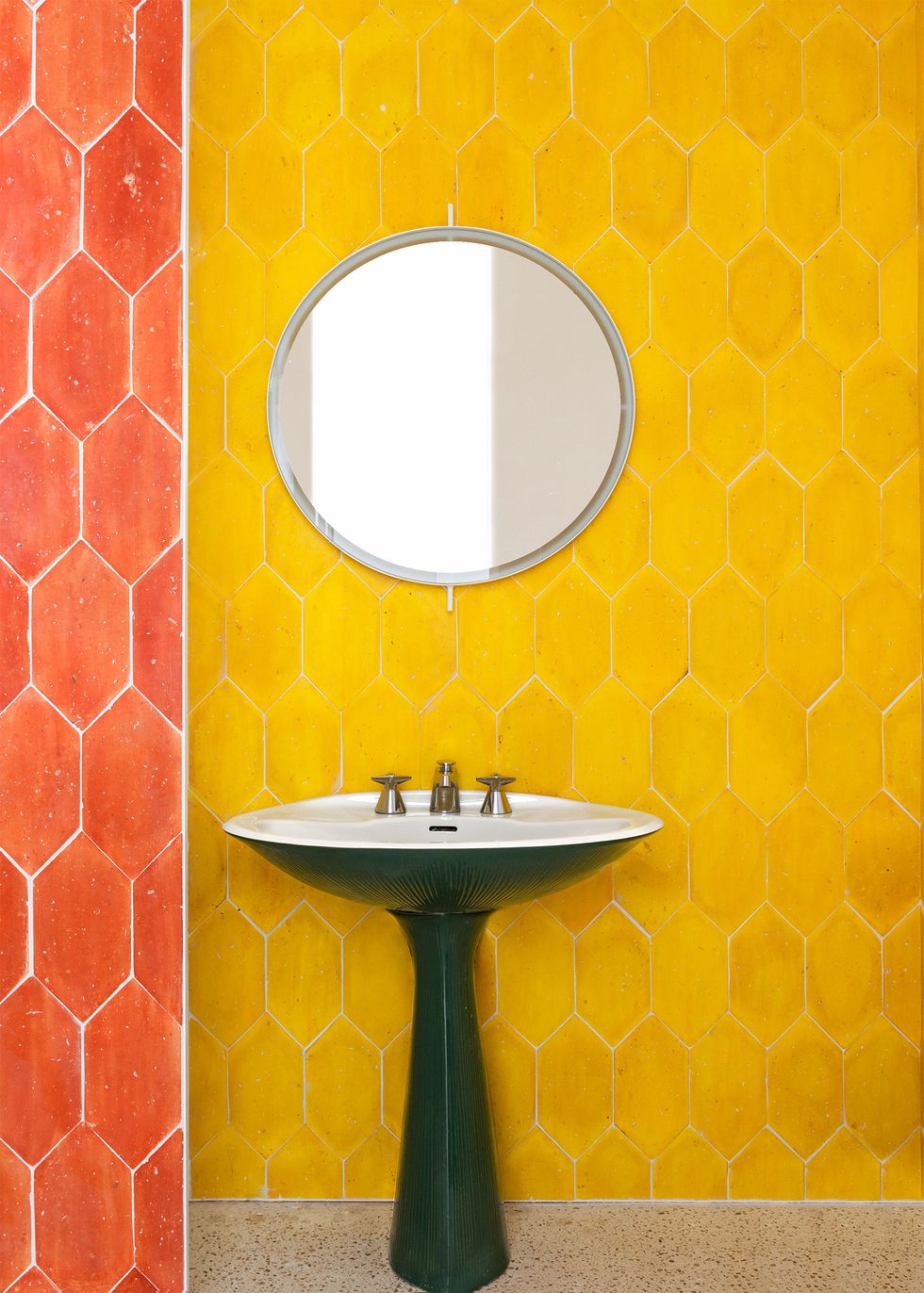 pedestal sink in bathroom with yellow tiles