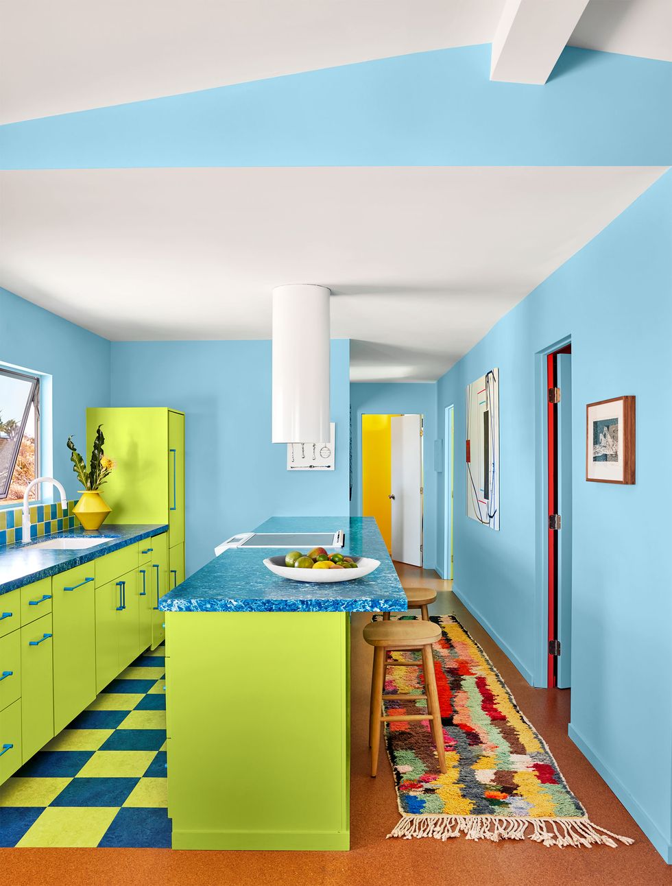 blue and lime green kitchen with speckled blue countertop and long colorful runner