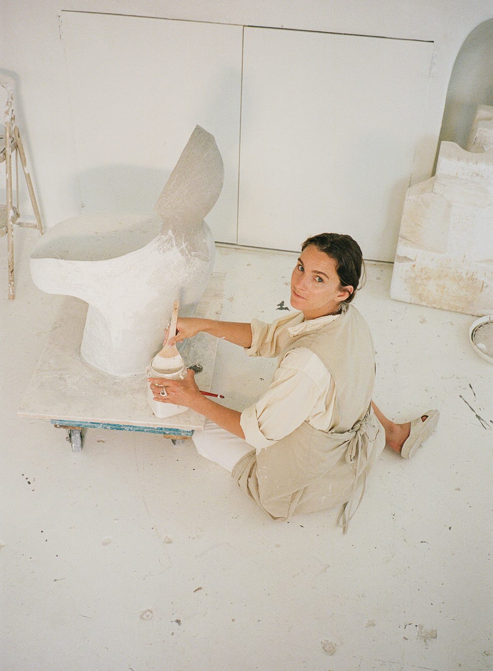 artisan working on a sculptural chair in a studio
