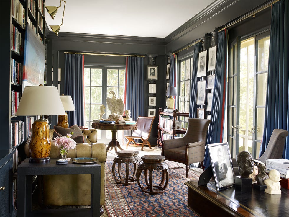 an office with lots of furniture and lamps and a rug and blue painted walls and matching blue draperies on windows on french doors and tall windows