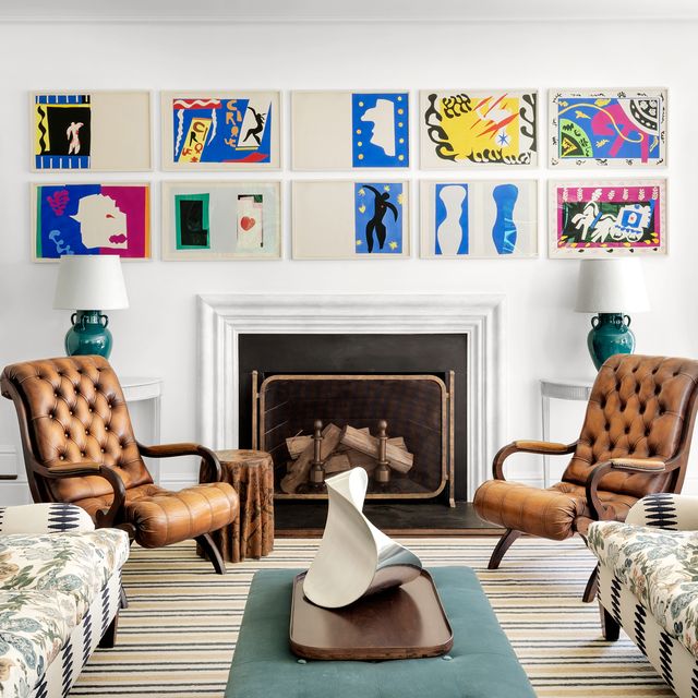 james huniford white living room with artwork over the mantel and brown leather chairs