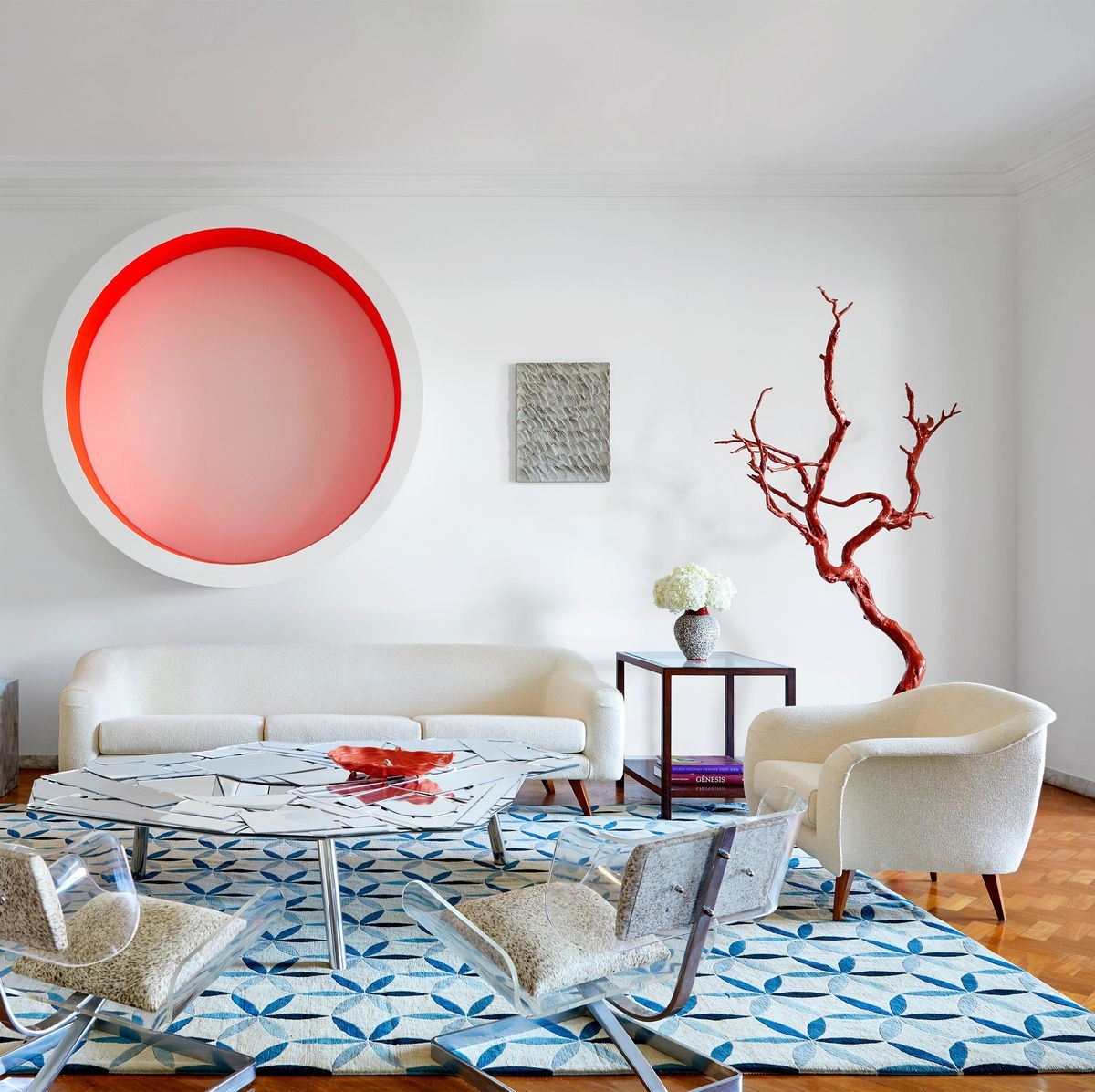 dining area with white round table at center with chairs sofa against wall and a large round pink and white piece of art on the wall